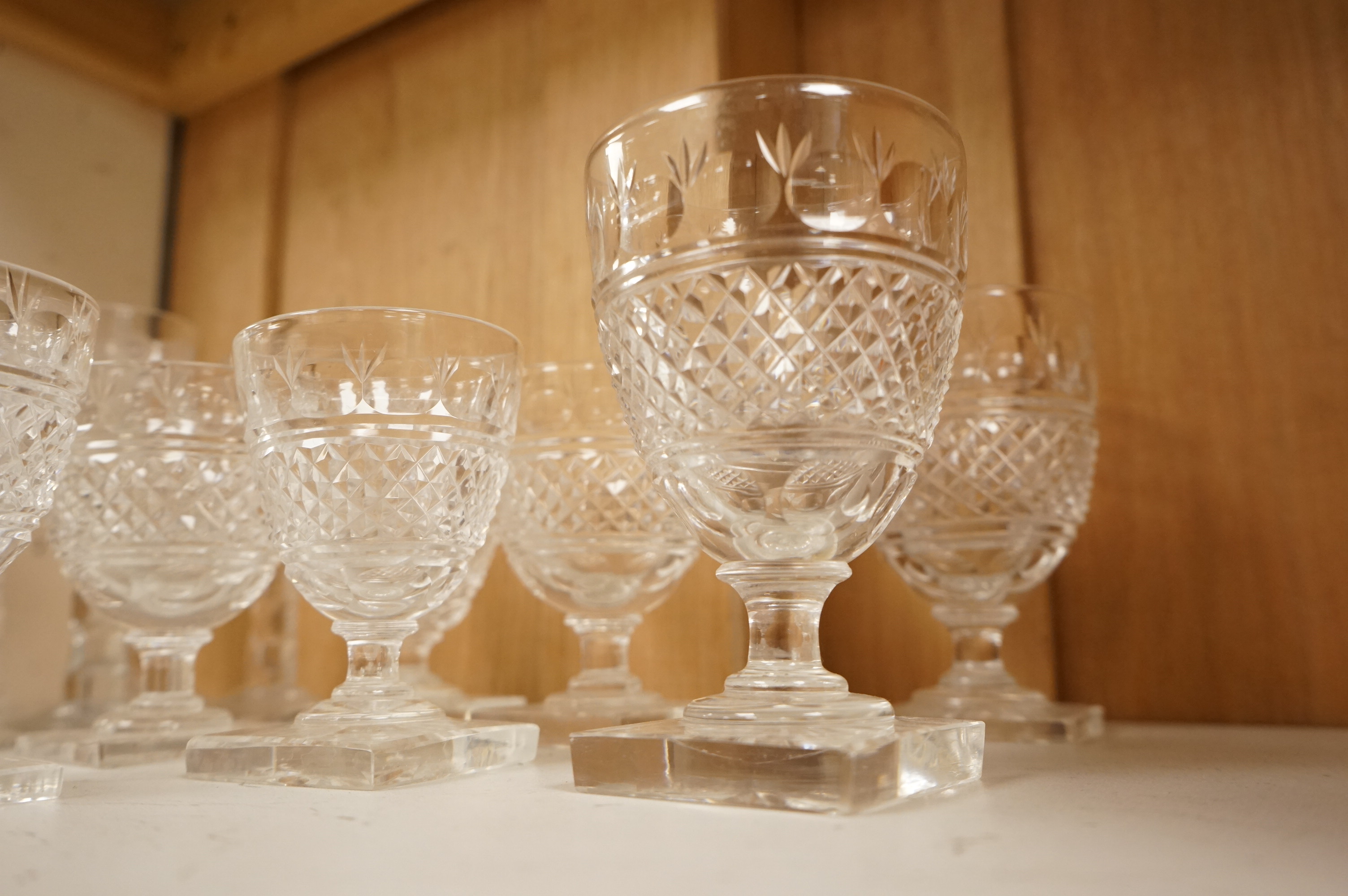 Seven Georgian style facet stem engraved wine glasses and a part suite of 19th centuy rummers, largest 14cm high